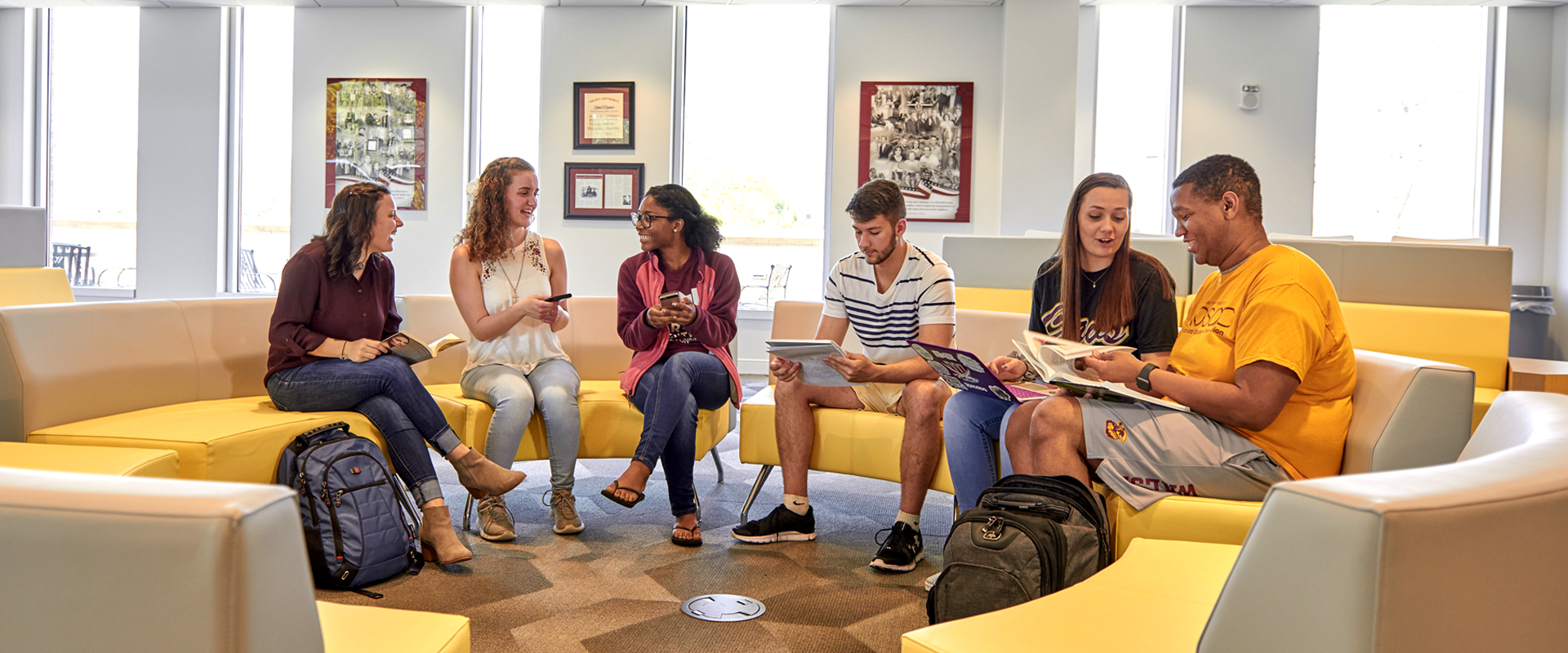 Photo of a group of students collaborating on a modern sofa